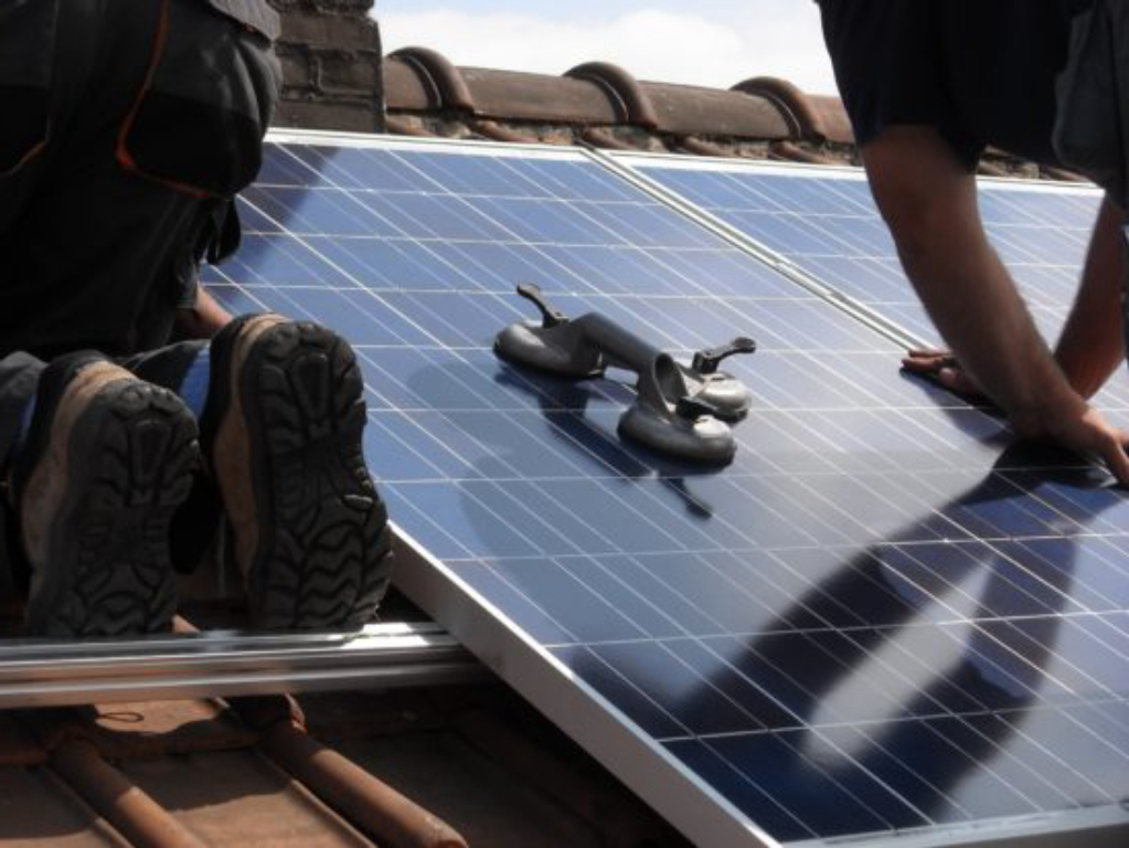 Installation de panneaux solaires sur le toit d'une maison.